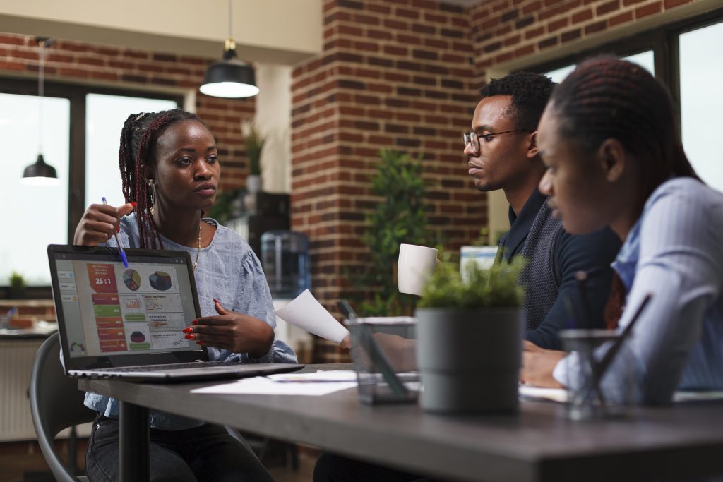 marketing company team leader presenting laptop business analytics chart african american businesswoman introducing colleagues new management business plan while modern office 1024x683